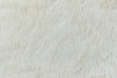 Pofuduk kumaşın yumuşak arka planı beyaz arka planda katlanır. Uzayı kopyala Düz yatıyordu. Leylak renginde sahte kürk kumaşında gevşek kıvrımlar var. Sıcak kış kıyafetlerinin ayrıntıları.