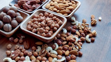 Masanın üstünde fındıklı ahşap kase. Sağlıklı yemek ve atıştırmalık. Ceviz, fıstık, badem, fındık ve fındık..