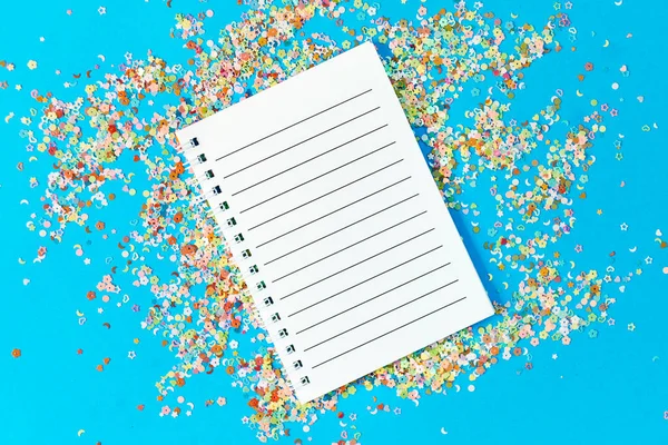 Empty notepad mockup on a pastel background. confetti texture. Festive glowing concept. The concept of making wishes. Festive and celebration concept. — Stock Photo, Image