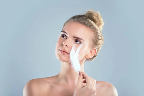 Retrato de chica atractiva con los ojos cerrados. hermosa mujer con una pluma blanca cerca de su cara. Concepto de cuidado de la piel de la cara y el cuerpo, piel brillante limpia fresca. —  Fotos de Stock