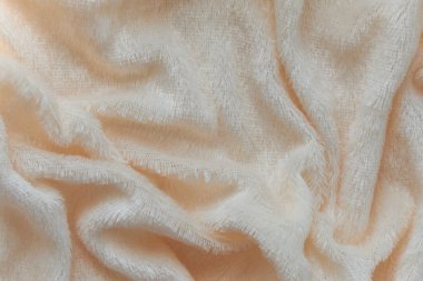 Pofuduk kumaşın yumuşak arka planı beyaz arka planda katlanır. Uzayı kopyala Düz yatıyordu. Leylak renginde sahte kürk kumaşında gevşek kıvrımlar var. Sıcak kış kıyafetlerinin ayrıntıları.