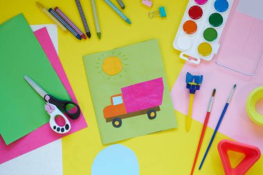 Okul malzemeleri, sarı arka planda kırtasiye malzemesi - manşet için yer. Çocuk kalemle çizmeye ve renkli kağıt uygulamaya hazır. Üst görünüm.