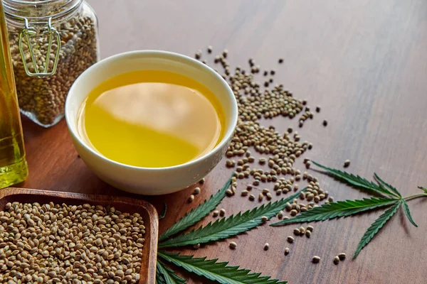Hamp på bordet, olje i en glasskrukke, blader av cannabis isolert på hvit bakgrunn – stockfoto