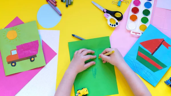 Σχολικά είδη, χαρτικά σε κίτρινο φόντο - χώρος για λεζάντα. Παιδί έτοιμο να ζωγραφίσει με μολύβια και να κάνει την εφαρμογή του χρωματιστού χαρτιού. Άνω όψη. — Φωτογραφία Αρχείου