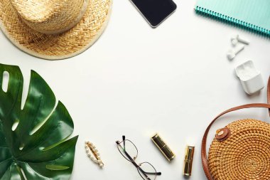 Yazlık kıyafet. Kahverengi haç çantası, kulaklık, hasır şapka. Düz yerde, üst tarafta. Kadın, yaz sokak tarzı. Aksesuarların kadın çerçevesi.