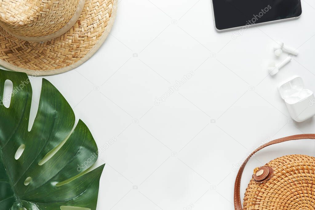 Summer outfit. Brown cross bag, headphones, straw hat. Flat lay, top view. Female, summer street style. Womens frame of accessories.