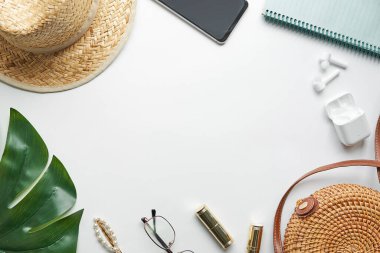 Yazlık kıyafet. Kahverengi haç çantası, kulaklık, hasır şapka. Düz yerde, üst tarafta. Kadın, yaz sokak tarzı. Aksesuarların kadın çerçevesi.