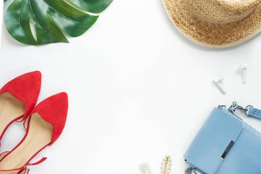 Yazlık kıyafet. Kahverengi haç çantası, kulaklık, hasır şapka. Düz yerde, üst tarafta. Kadın, yaz sokak tarzı. Aksesuarların kadın çerçevesi.