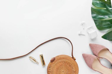 Yazlık kıyafet. Kahverengi haç çantası, kulaklık, pembe ayakkabılar. Düz yerde, üst tarafta. Kadın, yaz sokak tarzı. Aksesuarların kadın çerçevesi.