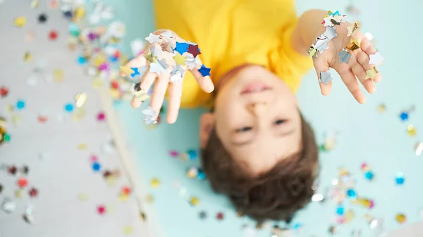 Happy birthday child. Photo of charming cute fascinating nice little boy blowing confetti at you to show her festive mood with emotional face expression. — Stock Photo, Image