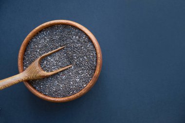 Beyaz arka planda izole edilmiş tahta kaşıkta Chia tohumları. Ağırlığı iyi ve yüksek protein ve fosfor, yüksek lif ve düşük kalori içeren Chia taneleri yenilebilir. Temiz yemek ve süper yemek.