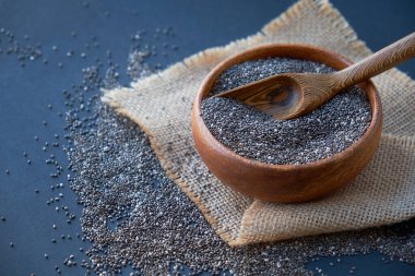 Beyaz arka planda izole edilmiş tahta kaşıkta Chia tohumları. Ağırlığı iyi ve yüksek protein ve fosfor, yüksek lif ve düşük kalori içeren Chia taneleri yenilebilir. Temiz yemek ve süper yemek.