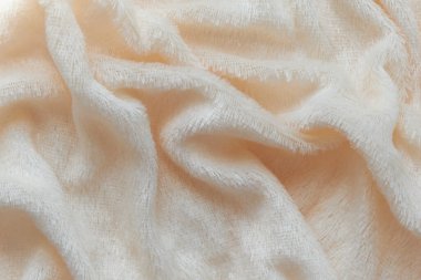 Pofuduk kumaşın yumuşak arka planı beyaz arka planda katlanır. Uzayı kopyala Düz yatıyordu. Leylak renginde sahte kürk kumaşında gevşek kıvrımlar var. Sıcak kış kıyafetlerinin ayrıntıları.