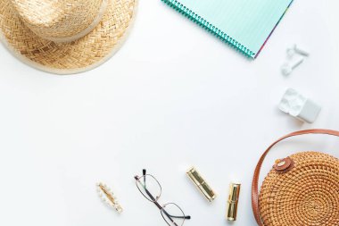 Yazlık kıyafet. Kahverengi haç çantası, kulaklık, hasır şapka. Düz yerde, üst tarafta. Kadın, yaz sokak tarzı. Aksesuarların kadın çerçevesi.