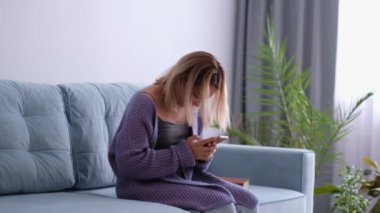 Skolyoz ve yan görüşlü akıllı telefon kullanan bir kadın. Yanlış duruş, skolyoz, ortopedi konsepti. Kadın. Kadın akıllı telefon kullanmaktan yüzü, başı ya da migreni ovar.