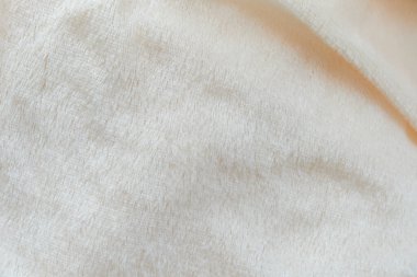 Pofuduk kumaşın yumuşak arka planı beyaz arka planda katlanır. Uzayı kopyala Düz yatıyordu. Leylak renginde sahte kürk kumaşında gevşek kıvrımlar var. Sıcak kış kıyafetlerinin ayrıntıları.