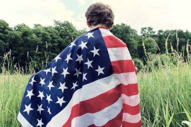 Vatansever tatiller. Amerikan bayrağı taşıyan genç bir çocuk. ABD 4 Temmuz 'u kutluyor..