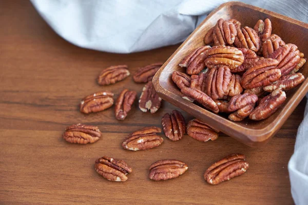 Tahta kasede fındıklar eski kahverengi masada, seçici odaklanma. Üst Manzara. Sağlıklı yemek ve atıştırmalık..