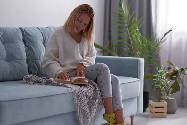 Mooie jonge vrouw genieten van het lezen van een boek thuis liggend op bed glimlachen in plezier in casual kleding — Stockfoto