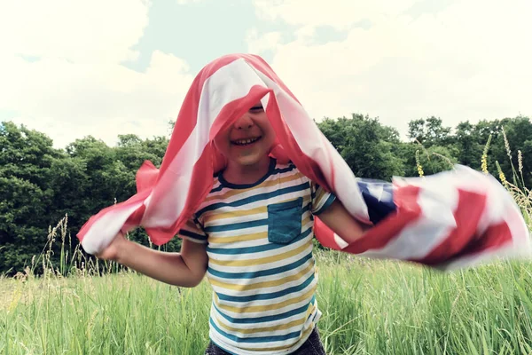 Patriotisk semester.Ung pojke med amerikansk flagga.USA firar 4 juli. — Stockfoto