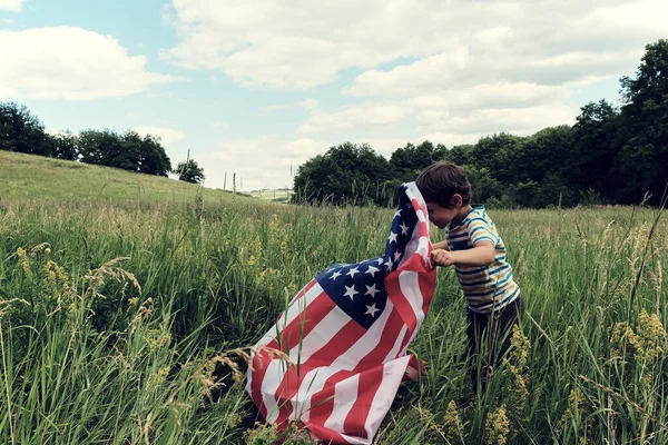 Patriotyczne wakacje.Młody chłopiec z flagą amerykańską.USA świętują 4 lipca. — Zdjęcie stockowe