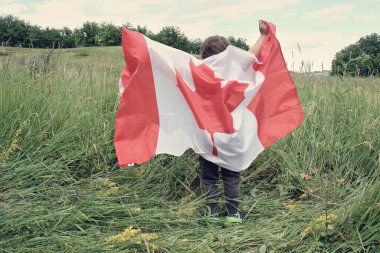 Mutlu çocuk koşarken Kanada bayrağını sallıyor