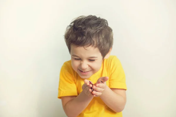 생일 축하 해. 매력적 이고 귀엽고 귀여운 작은 소년이 감정적 인 표정으로 축제 분위기를 보여 주기 위해 콘 페티를 불고 있는 사진. — 스톡 사진