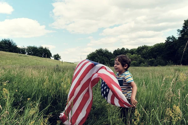 Patriotyczne wakacje.Młody chłopiec z flagą amerykańską.USA świętują 4 lipca. — Zdjęcie stockowe