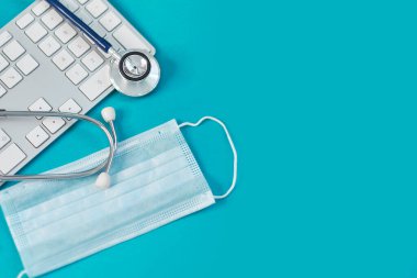 Klavye, tıbbi steteskop ve koruyucu maske. Evde kalıp uzaktan çalışma kavramı. İlaç, hastane, güvenlik, salgın, doktorlar arıyor, online, konsültasyon. Pankart.