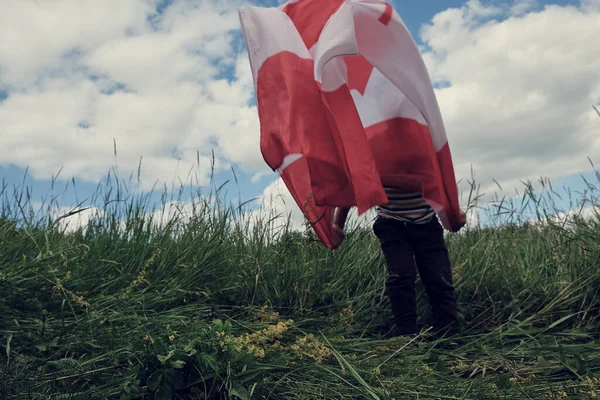 Szczęśliwy chłopiec machając flagą Kanady podczas biegania — Zdjęcie stockowe