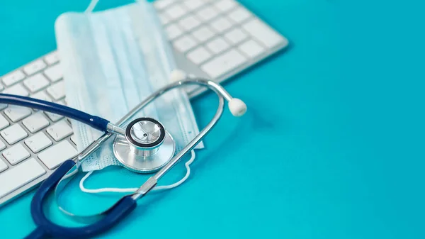 Teclado, estetoscopio médico y una máscara protectora. Concepto quedarse en casa y trabajo remoto. medicina, hospital, seguridad, epidemia, médicos llaman, en línea, consulta. Banner. — Foto de Stock