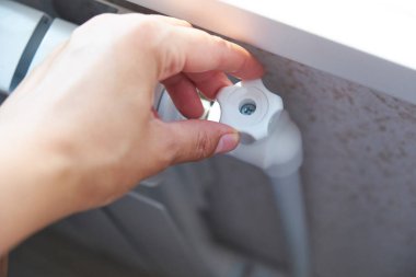 Termostat ayarlaması. Kadın eli radyatör ısısını ayarlıyor.