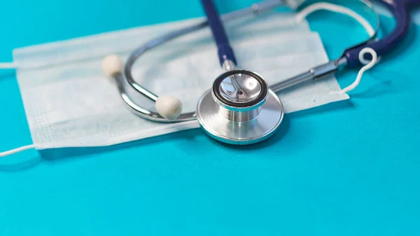 Estetoscopio médico y una máscara protectora. Concepto quedarse en casa y trabajo remoto. medicina, hospital, seguridad, epidemia, médicos llaman, en línea, consulta. Banner. — Foto de Stock