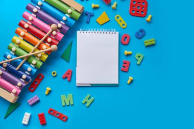 Okul gereçleri, altyazı için mavi arka planda kırtasiye malzemesi. Okul konseptine geri dönelim. Okul, eğitim ve öğrenme konsepti. Çocuklar için yaratıcılık. Üst görünüm renkli arkaplan. Düz yatıyordu