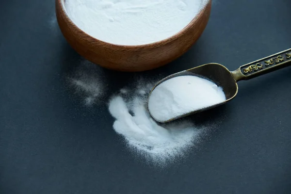 Glass bowl of baking soda. Spoonful of bicarbonate.