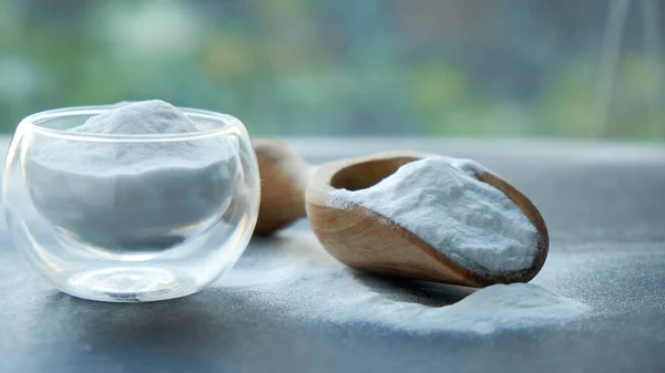 Glass bowl of baking soda. Spoonful of bicarbonate.