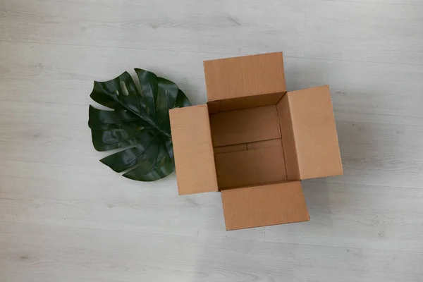 Posa piatta di scatola di cartone aperta vuota su superficie di legno — Foto Stock
