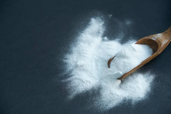 Glass bowl of baking soda. Spoonful of bicarbonate.