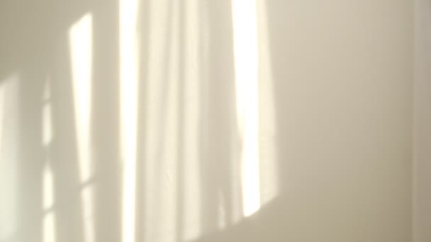 Sole del mattino che illumina la stanza, sovrapposizioni di sfondo ombra. Sventolando tulle bianco vicino alla finestra. — Video Stock