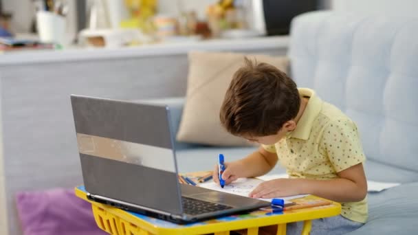 Concepto de lección de aprendizaje a distancia en línea. Niño niño colegial usando tableta computadora portátil para la tarea de la escuela, estudiando en casa. — Vídeos de Stock