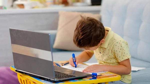 Petit garçon en classe virtuelle. L'école à la maison. petit garçon mignon prend une leçon de dessin en ligne. l'enfant est engagé dans la créativité à la maison — Photo