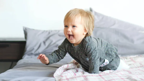 Portrait of very sweet little child. 1 year old baby crawling on the bed — Stock Photo, Image