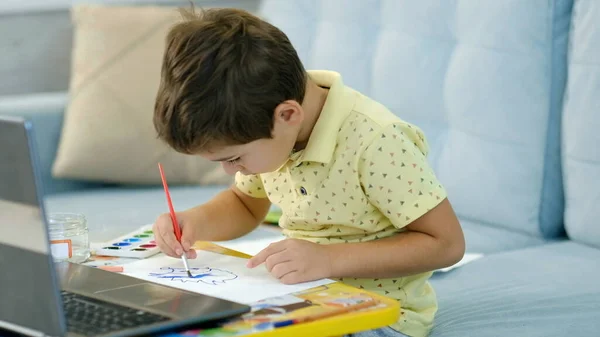 Little boy in virtual class. School at home. little cute boy is taking an online drawing lesson. the child is engaged in creativity at home — Stock Photo, Image