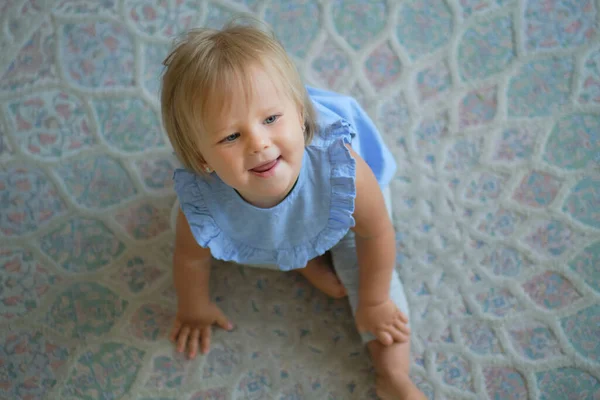 Gyermekkor, gyermekkor és emberek koncepciója. Boldog kislány, aki otthon ül a földön. felülnézetből — Stock Fotó