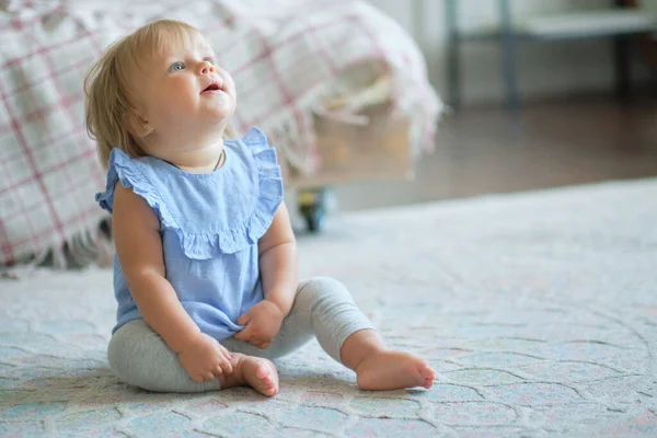 Barndom, barndom och människor koncept. glad liten flicka sitter på mattan hemma. — Stockfoto
