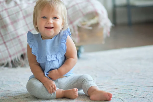 Barndom, barndom och människor koncept. glad liten flicka sitter på mattan hemma. — Stockfoto