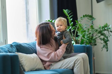Sevgi dolu bir aile. Anne ve çocuk oynuyorlar, öpüşüyorlar ve sarılıyorlar.