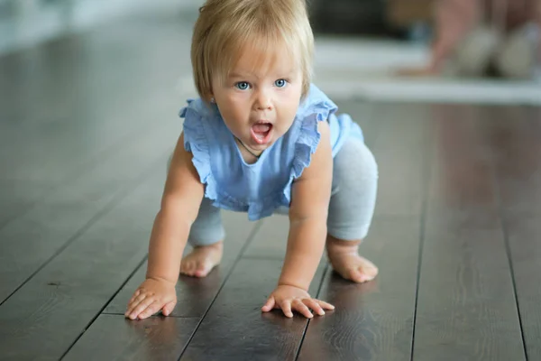 Childhood, babyhood and people concept. happy little baby girl sitting on a wooden floor at home. — Stock Photo, Image