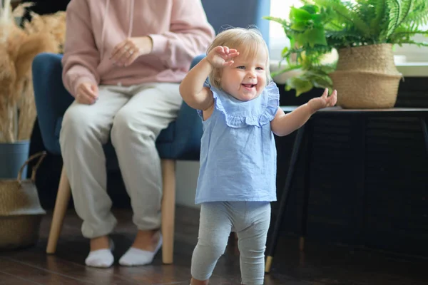 Toddler strive to explore the room. the child does not want to sit still. the girl is actually running away from her mother. — Stock Photo, Image