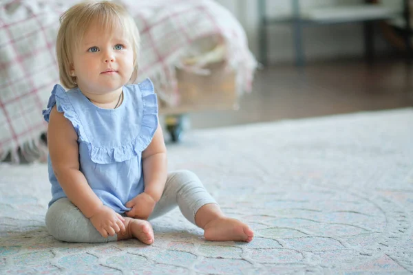 Barndom, barndom och människor koncept. glad liten flicka sitter på mattan hemma. — Stockfoto